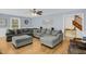 Light-filled living room with plush gray sectional and hardwood floors, creating a cozy ambiance at 2746 Moss Creek Loop, Elon, NC 27244