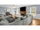 Comfortable living room showcasing large sectional, brick fireplace, and abundant natural light at 2746 Moss Creek Loop, Elon, NC 27244