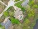 Aerial view showcases a home with an inviting pool area, lush landscaping, and a circular driveway surrounded by greenery at 2922 Bells Pointe Ct, Apex, NC 27539