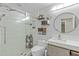Bright bathroom with a glass shower, decorative shelves and modern vanity with a round mirror at 2922 Bells Pointe Ct, Apex, NC 27539