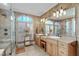 Upscale bathroom featuring travertine tile, double sinks, and large glass shower with decorative windows at 2922 Bells Pointe Ct, Apex, NC 27539