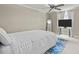Modern bedroom with neutral tones, large television, mirror, and white bed with blue accents at 2922 Bells Pointe Ct, Apex, NC 27539