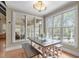 Bright breakfast nook features large windows with serene outdoor views and a farmhouse-style table and benches at 2922 Bells Pointe Ct, Apex, NC 27539