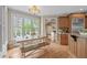 Charming breakfast nook with large windows and a farm table leads to the kitchen and living room spaces at 2922 Bells Pointe Ct, Apex, NC 27539