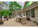 Beautiful outdoor deck featuring comfortable wicker seating, a dining table, and a scenic view of the well-maintained backyard at 2922 Bells Pointe Ct, Apex, NC 27539