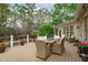 Inviting deck with wicker furniture, outdoor dining set, and views of the landscaped backyard and flowering trees at 2922 Bells Pointe Ct, Apex, NC 27539