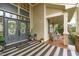 Grand front entryway with striking doors, transom windows, a striped mat, and access to a cozy covered porch at 2922 Bells Pointe Ct, Apex, NC 27539