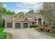 Attractive home with a three-car garage, a large driveway, beautiful stone accents, and professionally landscaped grounds at 2922 Bells Pointe Ct, Apex, NC 27539