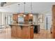 Spacious kitchen featuring a large island with granite countertops, custom cabinetry, and stainless steel appliances at 2922 Bells Pointe Ct, Apex, NC 27539