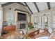 Vaulted living room with a stone fireplace, built-in cabinets, large windows, and hardwood floors at 2922 Bells Pointe Ct, Apex, NC 27539