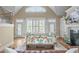 Bright and airy living room boasts a vaulted ceiling, large windows, and a cozy fireplace at 2922 Bells Pointe Ct, Apex, NC 27539