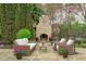 Inviting outdoor seating area with a stone fireplace, perfect for enjoying the tranquil lake view and lush surroundings at 2922 Bells Pointe Ct, Apex, NC 27539