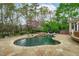 Beautifully designed backyard with a freeform pool, spa, stone patio, and lush landscaping for ultimate relaxation at 2922 Bells Pointe Ct, Apex, NC 27539