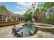 Backyard oasis with a sparkling pool, attached spa, lounge seating, an outdoor fireplace, and meticulously landscaped greenery at 2922 Bells Pointe Ct, Apex, NC 27539
