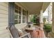 Charming covered porch featuring comfortable seating, stone pillar accents, and views of the professionally landscaped yard at 2922 Bells Pointe Ct, Apex, NC 27539
