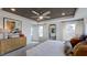 This bedroom features a tray ceiling with a ceiling fan, a dresser, an area rug, and many windows at 300 Seagraves Creek Ln, Holly Springs, NC 27540