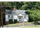 Charming cottage-style home with white siding, brick foundation, and well-maintained landscaping at 301 Dunstan Ave, Durham, NC 27707