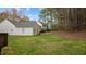 Grassy backyard with a view of a home featuring neutral siding and a well-maintained lawn and foliage at 301 Tillamook Dr, Wake Forest, NC 27587