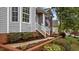 Close-up of home entrance with gray siding, brick foundation, and well-maintained landscaping at 301 Tillamook Dr, Wake Forest, NC 27587
