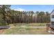 Backyard view showing a pond and wooded area, and a home with a deck and stairs at 3020 Mavisbank Cir, Apex, NC 27502