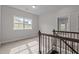 Upstairs hallway with dark wood railing, a view of windows, and grey carpet at 3020 Mavisbank Cir, Apex, NC 27502