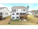 Back exterior of a two-story home with multiple windows, a wood deck, and a ground level patio at 3020 Mavisbank Cir, Apex, NC 27502