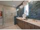 Modern bathroom featuring stylish tile work, a glass enclosed shower and double sink vanity with gold fixtures at 303 Gilliland Rd, Siler City, NC 27344