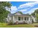 Charming home featuring a welcoming front porch, white siding, and a well-manicured lawn at 308 Charles St, Henderson, NC 27536