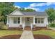 Charming single-story home featuring a covered porch, painted white siding, and a well-maintained front lawn at 308 Charles St, Henderson, NC 27536