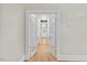 Hallway with hardwood floors and paneled doors leading to other rooms, creating an open and inviting atmosphere at 308 Charles St, Henderson, NC 27536