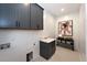 Functional laundry room with shiplap walls, sink, storage cabinets, and tile flooring at 315 Gilliland Rd, Siler City, NC 27344