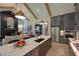 Open-concept living space features a stone fireplace, exposed beams, and a kitchen island at 321 Gilliland Rd, Siler City, NC 27344
