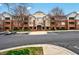 Spacious brick condo building featuring a well-maintained parking lot and attractive landscaping at 3700 Baron Cooper Pass # 104, Raleigh, NC 27612