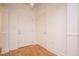 Clean condo hallway with hardwood floors and neutral-toned walls, showing doorways and electrical outlets at 3700 Baron Cooper Pass # 104, Raleigh, NC 27612