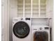 Laundry room featuring front loading washer, dryer, and open shelving at 3700 Baron Cooper Pass # 104, Raleigh, NC 27612