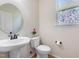 Bright powder room featuring a pedestal sink, decorative window, and neutral paint at 3729 Norman Blalock Rd, Willow Springs, NC 27592