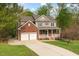 Two-story home boasts a long driveway and attached two-car garage, showcasing a well-manicured lawn at 3729 Norman Blalock Rd, Willow Springs, NC 27592