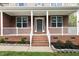 Welcoming front porch with brick stairs, white railing, and a gray front door with a wreath at 3729 Norman Blalock Rd, Willow Springs, NC 27592