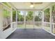 Relaxing screened-in porch with gray floors, a ceiling fan, and a scenic view of the treed yard at 3729 Norman Blalock Rd, Willow Springs, NC 27592