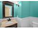 Turquoise half bathroom featuring a decorative dark wood vanity with unique light fixture at 432 Kings Hollow Dr, Raleigh, NC 27603