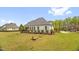 Exterior rear view of home with screened porch, patio seating, and a well-maintained lawn at 432 Kings Hollow Dr, Raleigh, NC 27603