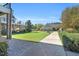 Spacious backyard with a stone patio, lush landscaping, and view of nearby community buildings at 45 Summersweet Ln, Chapel Hill, NC 27516