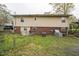 View of home's backyard featuring chainlink fence, AC units, grass and lower-level brickwork at 518 N Gutherie Ave, Durham, NC 27703