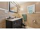 Bathroom with a dark vanity cabinet, framed mirror, and tile walls at 518 N Gutherie Ave, Durham, NC 27703