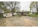 Home's carport featuring gravel driveway, storage shed, and access to back of the home at 518 N Gutherie Ave, Durham, NC 27703