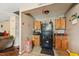 Compact kitchen with oak cabinets and black appliances at 518 N Gutherie Ave, Durham, NC 27703