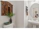 Stylish powder room with a pedestal sink, decorative mirror, and charming accents at 53 Azul Dr, Clayton, NC 27520