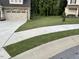 Landscaped lawn, sidewalk, and two-car garage with stone accents on a sunny day at 53 Azul Dr, Clayton, NC 27520
