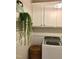 Laundry area with white cabinets, hanging plant, and modern washing machine at 53 Azul Dr, Clayton, NC 27520