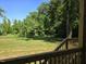 Lush backyard view from wooden deck featuring abundant trees and green space at 5480 Thom Rd, Mebane, NC 27302